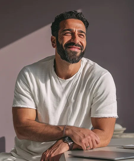 Женщина улыбается, сидя на кровати, тёплый домашний интерьер