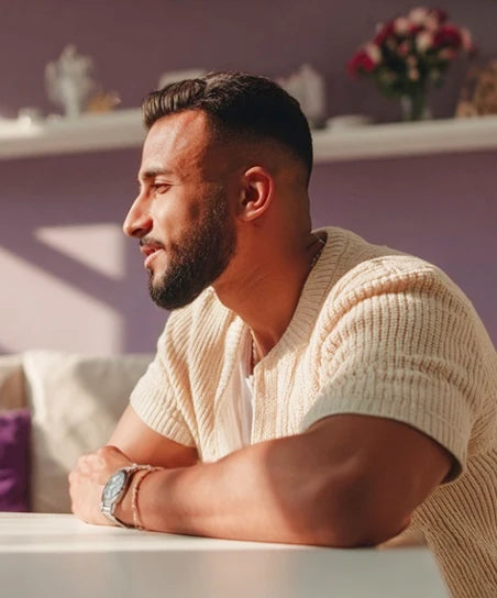 Мужчина сидит боком, разговаривает и улыбается